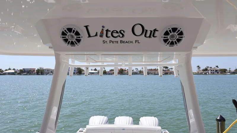  Yacht Photos Pics 2022 Regal 38 SAV boat with "Lites Out" sign, St. Pete Beach, FL, scenic water view.