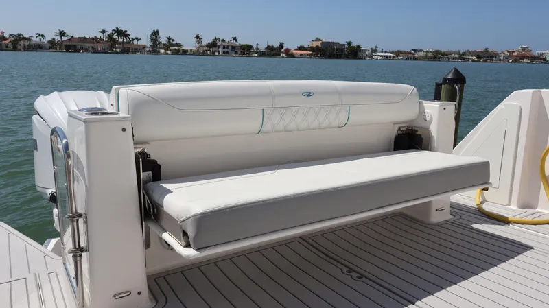  Yacht Photos Pics 2022 Regal 38 SAV boat with white seating on deck, overlooking calm waters.