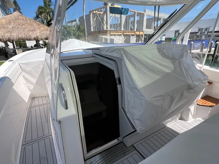 Yacht Photos Pics 2022 Regal 38 SAV boat with open cabin entrance, docked near a tropical setting.