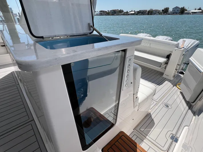  Yacht Photos Pics 2022 Regal 38 SAV yacht interior with open storage compartment, docked by the water.