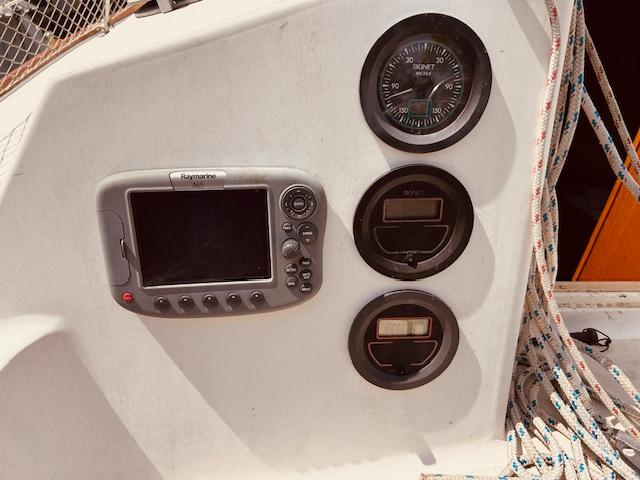 Control panel of a 1986 Pearson 28 sailboat with navigation instruments and ropes.