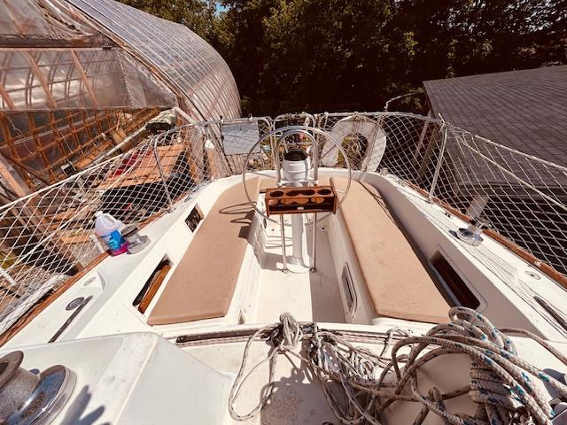 1986 Pearson 28 sailboat deck with seating, ropes, and netting in a sunny setting.