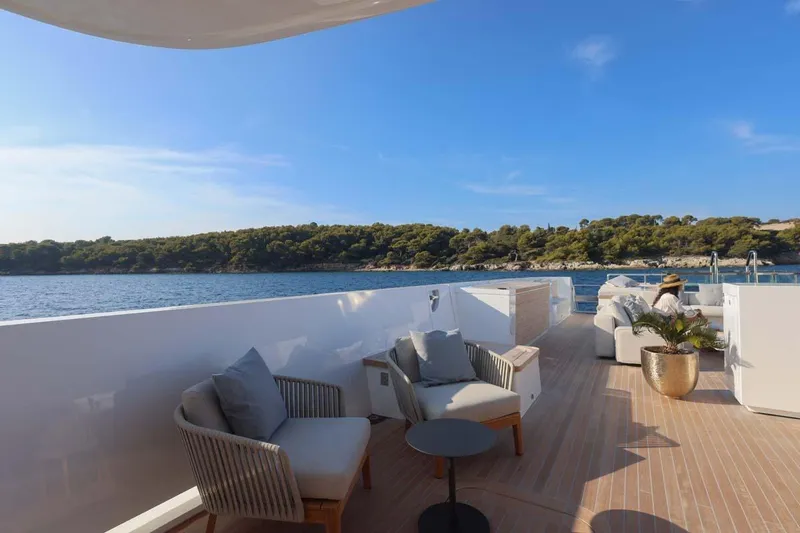 Oceanic 143 Yacht Photos Pics Luxurious 2023 Canados Expedition Yacht deck with elegant seating, overlooking serene coastal waters.