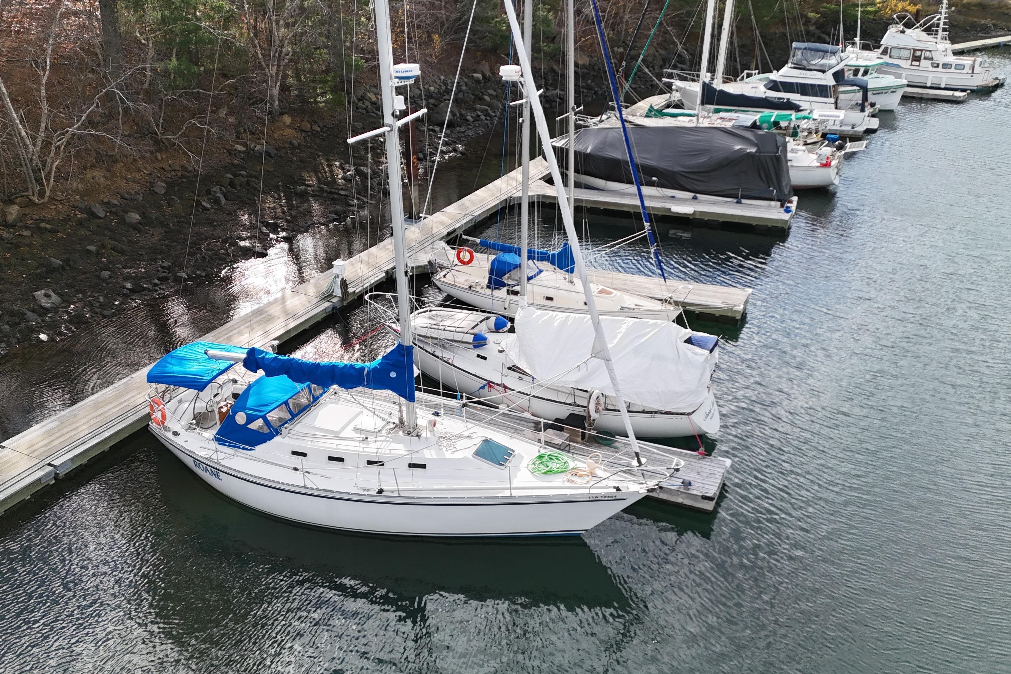 Sailboats docked at a marina, featuring a 1985 CS 36 model with blue covers.