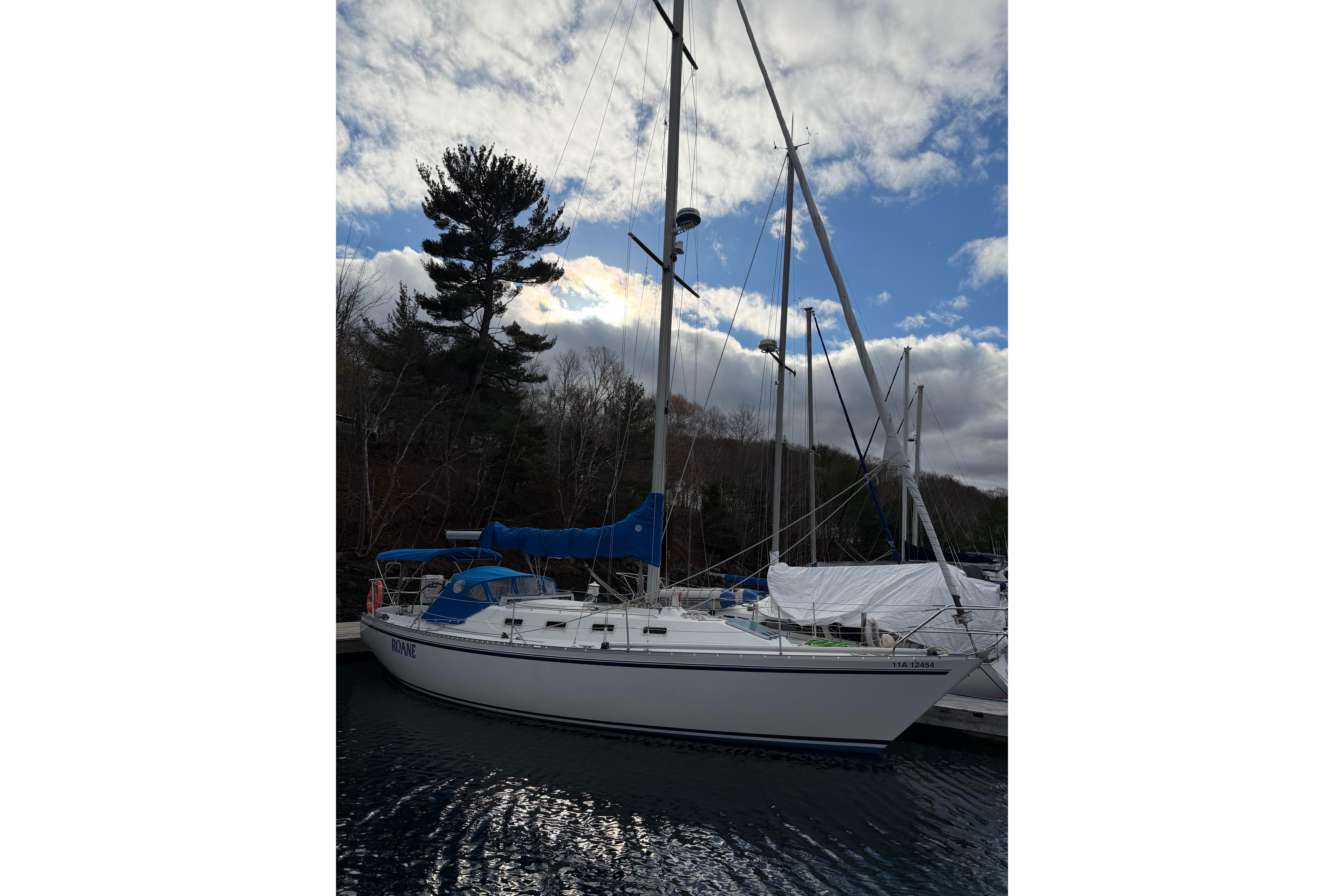 1985 CS 36 sailboat docked under a partly cloudy sky.