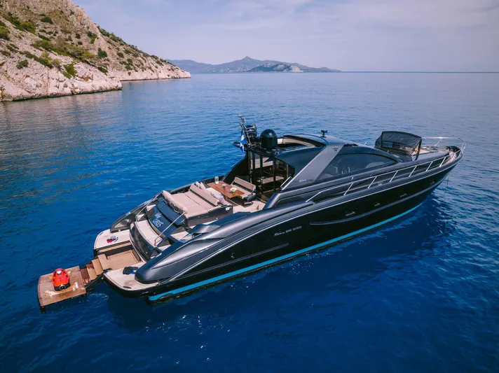  Yacht Photos Pics Luxurious 2006 Riva 68 Ego yacht cruising in clear blue waters near rocky coastline.