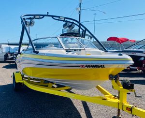 2006 Tahoe Q4 Sport boat in bright yellow on trailer, parked outdoors.