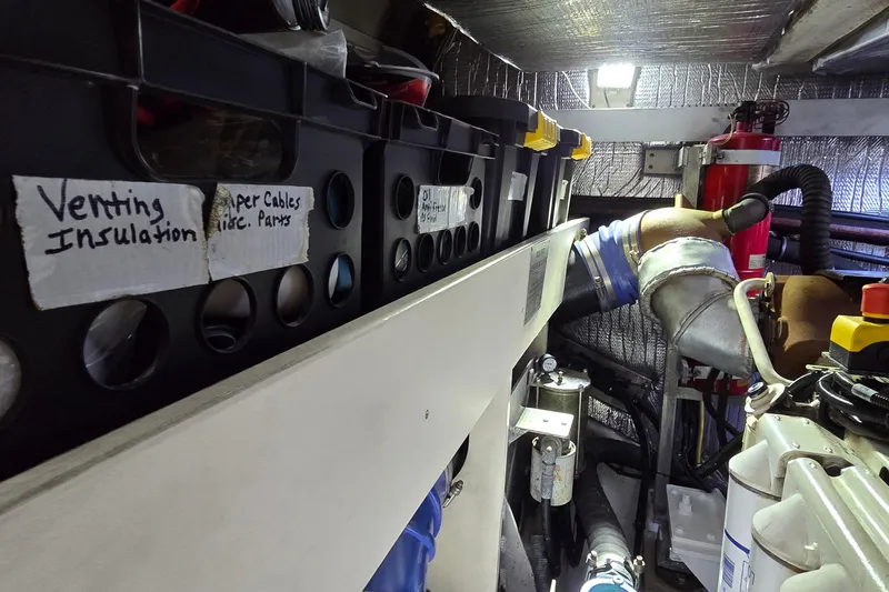  Yacht Photos Pics Engine room of 2006 Cruisers Yachts 520 Express with labeled storage bins and equipment.