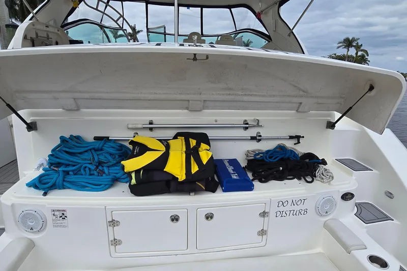  Yacht Photos Pics 2006 Cruisers Yachts 520 Express storage area with ropes, life jacket, and "Do Not Disturb" sign.