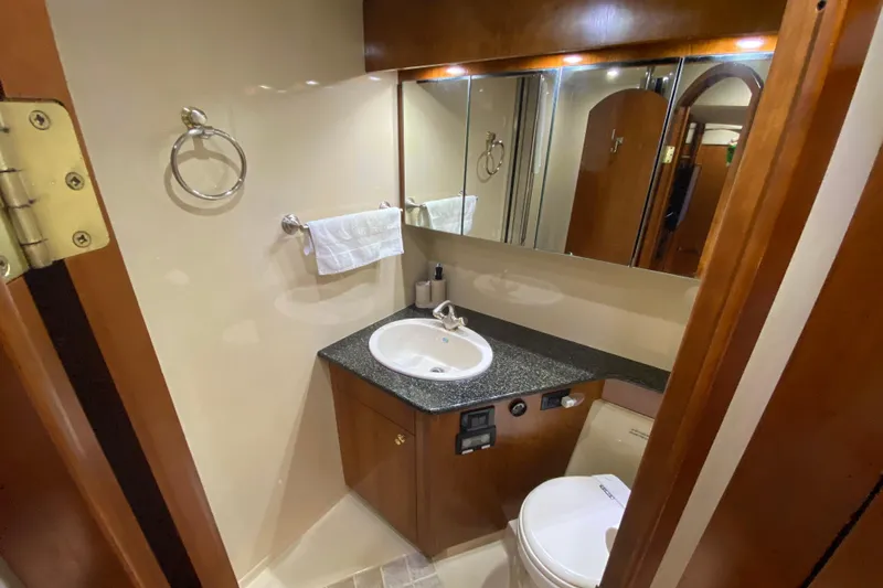  Yacht Photos Pics Luxurious bathroom in 2006 Cruisers Yachts 520 Express with modern fixtures and wood accents.