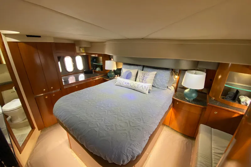  Yacht Photos Pics Luxurious 2006 Cruisers Yachts 520 Express bedroom with elegant wood cabinetry and cozy bedding.
