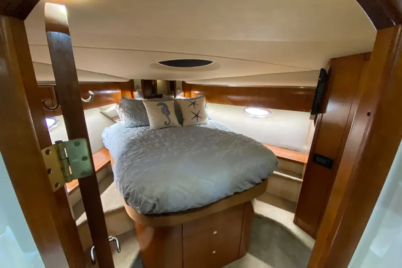  Yacht Photos Pics Luxurious 2006 Cruisers Yachts 520 Express cabin interior with cozy bed and elegant wood finish.