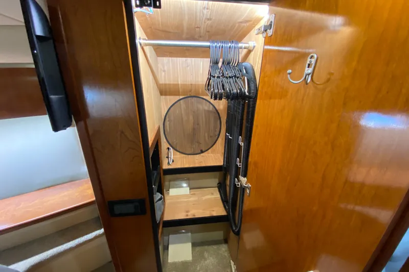  Yacht Photos Pics 2006 Cruisers Yachts 520 Express interior closet with hangers and wooden finish.