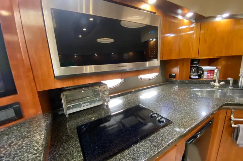  Yacht Photos Pics Luxurious 2006 Cruisers Yachts 520 Express kitchen with modern appliances and sleek countertops.