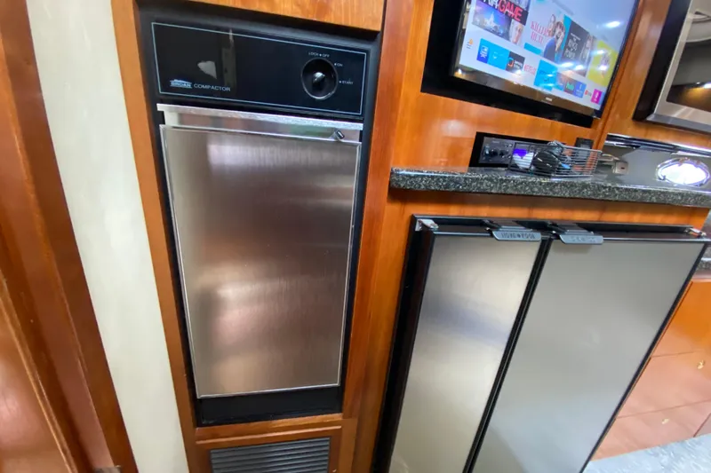  Yacht Photos Pics 2006 Cruisers Yachts 520 Express kitchen with stainless steel appliances and wood cabinetry.