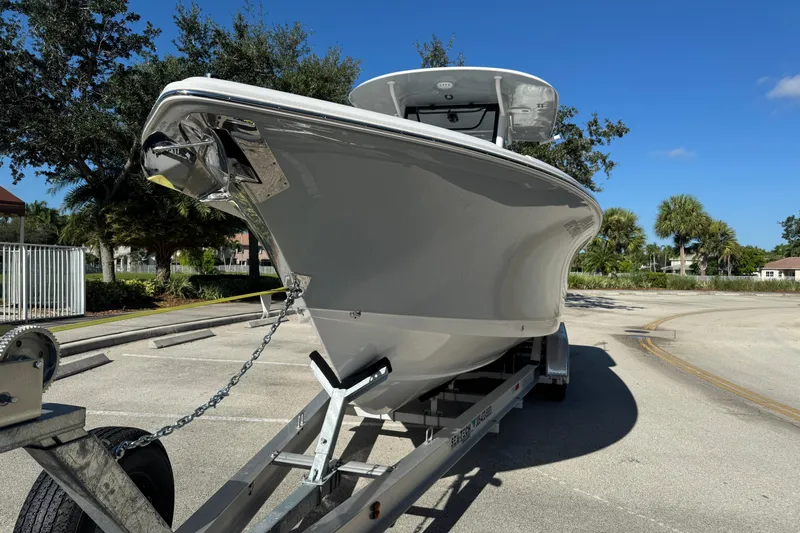  Yacht Photos Pics 2025 Sea Hunt Ultra 305 SE boat on trailer, parked outdoors under clear blue sky.
