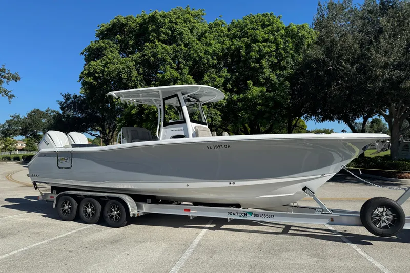 Yacht Photos Pics 2025 Sea Hunt Ultra 305 SE boat on trailer, parked outdoors under clear blue sky.