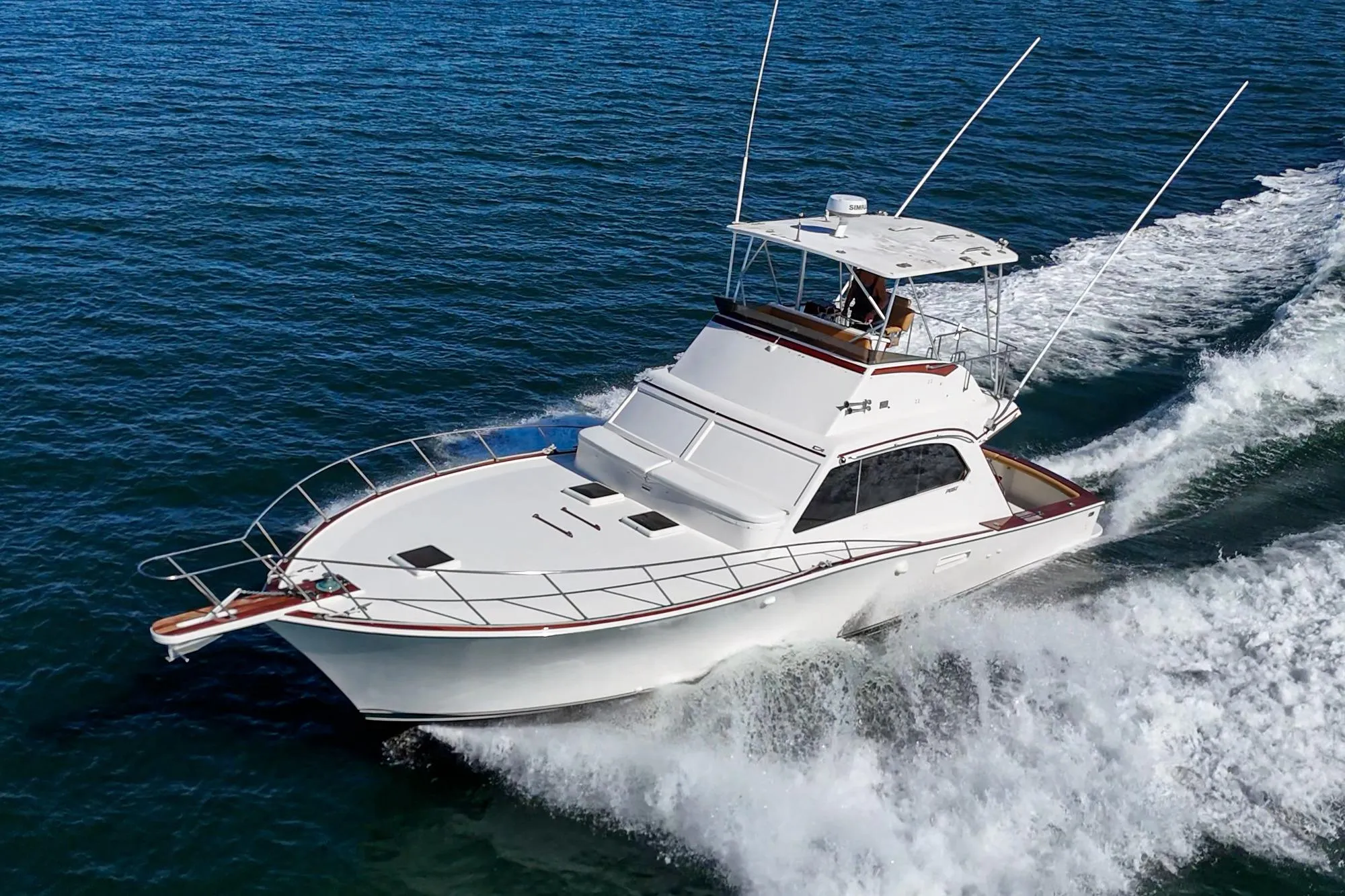 1984 Post 43 yacht cruising on open water, creating a dynamic wake.