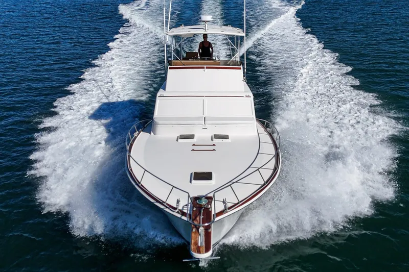 Un Dia Yacht Photos Pics 1984 Post 43 yacht cruising on open water, creating a dynamic wake.