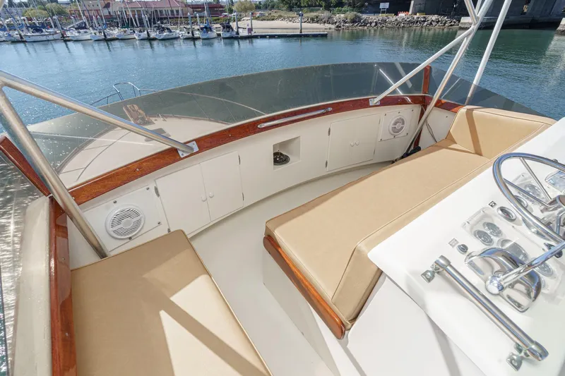 Un Dia Yacht Photos Pics Flybridge of 1984 Post 43 yacht with beige seating and marina view.