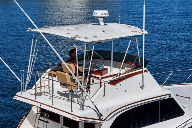 Un Dia Yacht Photos Pics 1984 Post 43 yacht with upper deck, navigating calm blue waters.