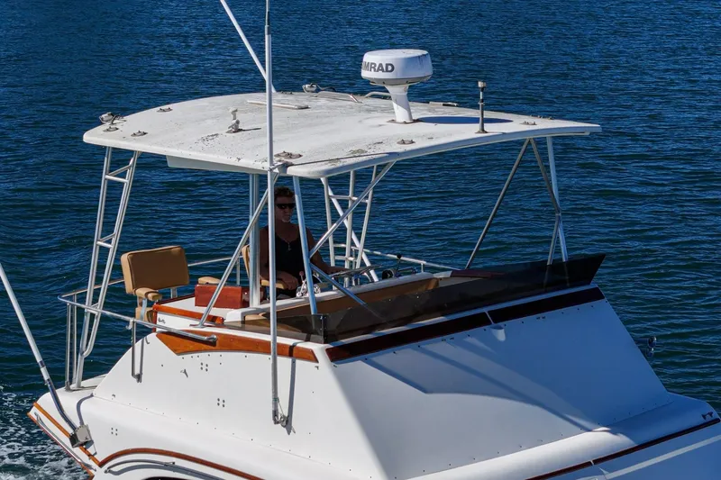 Un Dia Yacht Photos Pics 1984 Post 43 boat cruising on blue water with a person at the helm.