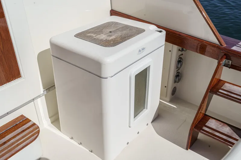 Un Dia Yacht Photos Pics White marine icebox on a 1984 Post 43 boat deck with wooden accents.