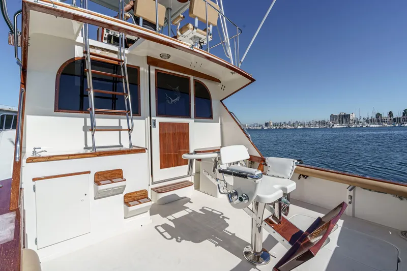 Un Dia Yacht Photos Pics 1984 Post 43 yacht deck with fishing chairs, ladder, and marina view.