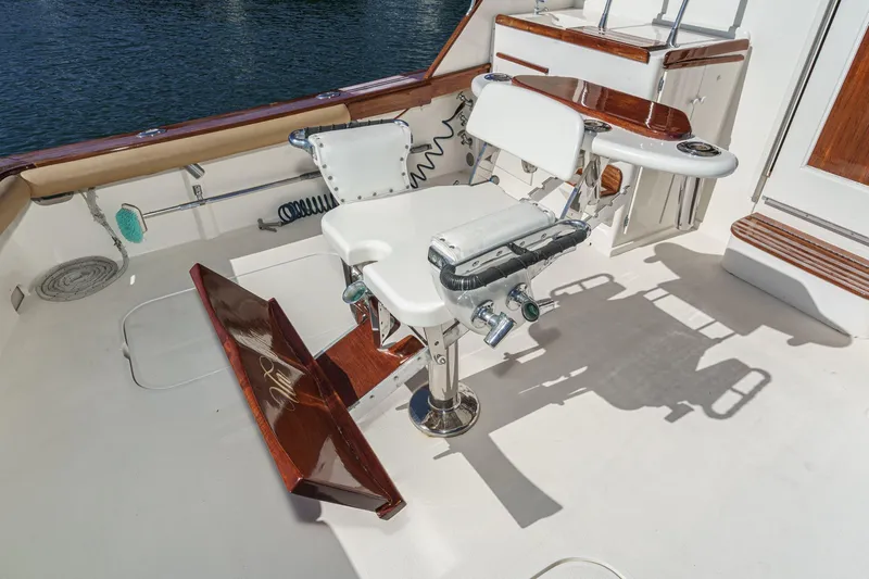 Un Dia Yacht Photos Pics Fishing chair on 1984 Post 43 yacht deck, featuring wood accents and ocean backdrop.