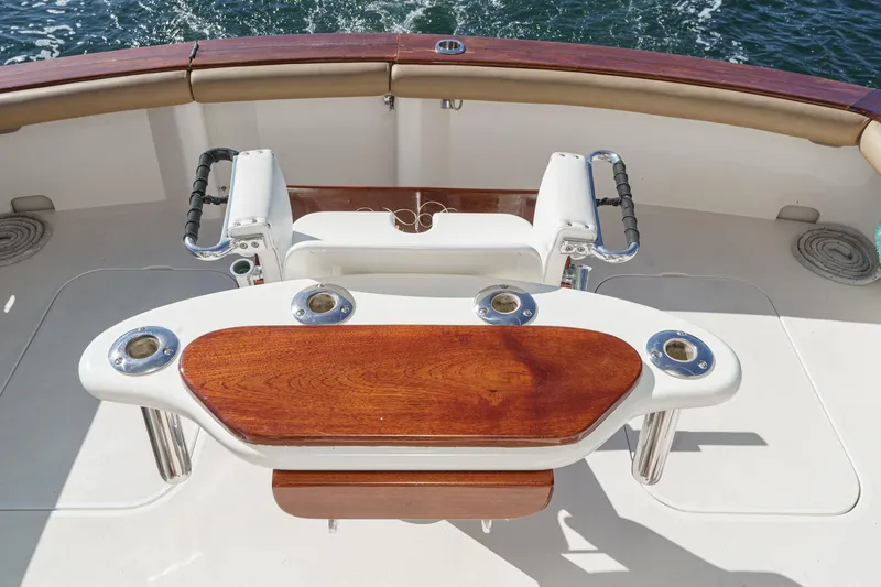 Un Dia Yacht Photos Pics Fishing chair on 1984 Post 43 boat with wooden table and rod holders.