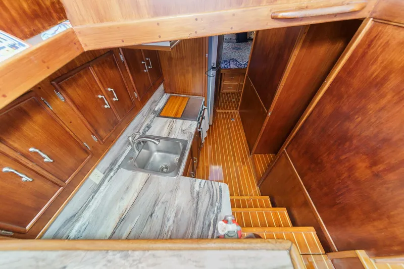 Un Dia Yacht Photos Pics 1984 Post 43 yacht interior with wooden cabinets, marble countertop, and stainless steel sink.