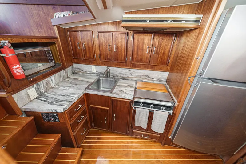 Un Dia Yacht Photos Pics Vintage 1984 Post 43 yacht kitchen with wood cabinets and marble countertops.