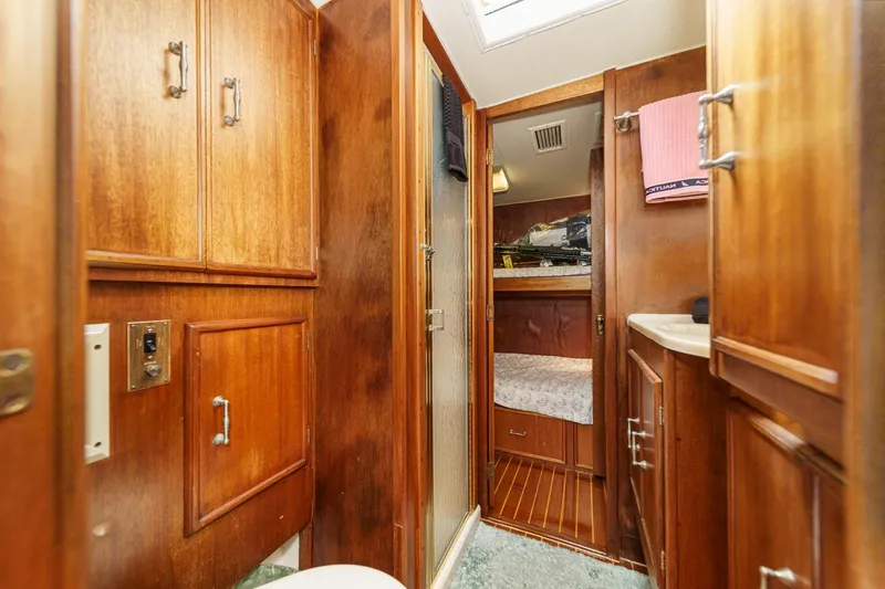 Un Dia Yacht Photos Pics Wood-paneled interior of a 1984 Post 43 yacht with cozy cabin and storage.