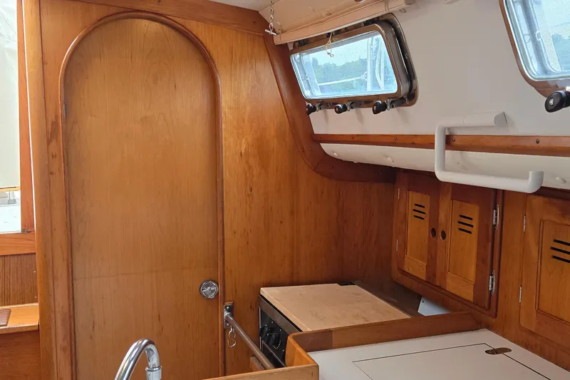Orion Yacht Photos Pics Interior of a 1997 Freedom 35 sailboat with wooden cabinetry and porthole windows.