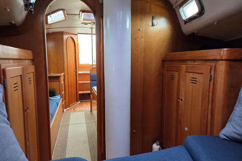 Orion Yacht Photos Pics Interior of a 1997 Freedom 35 sailboat with wooden cabinetry and blue seating.