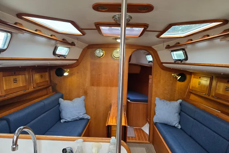Orion Yacht Photos Pics Cozy interior of a 1997 Freedom 35 sailboat with blue seating and wooden accents.