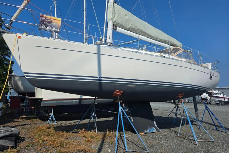 Orion Yacht Photos Pics Sailboat Freedom 35, 1997 model, on stands in a boatyard under clear blue sky.
