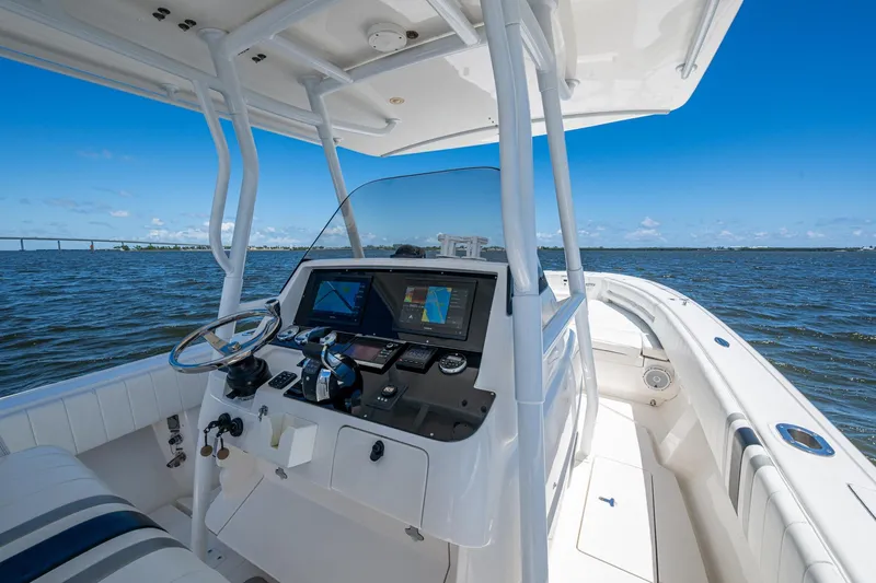  Yacht Photos Pics 2010 Intrepid 323 OPEN boat cockpit with navigation system, steering wheel, and ocean view.