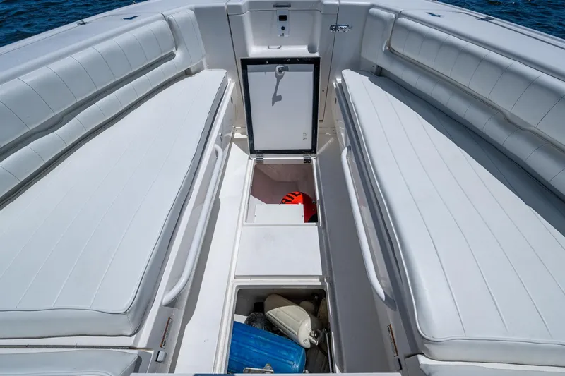  Yacht Photos Pics 2010 Intrepid 323 OPEN boat interior with white seating and storage compartments.