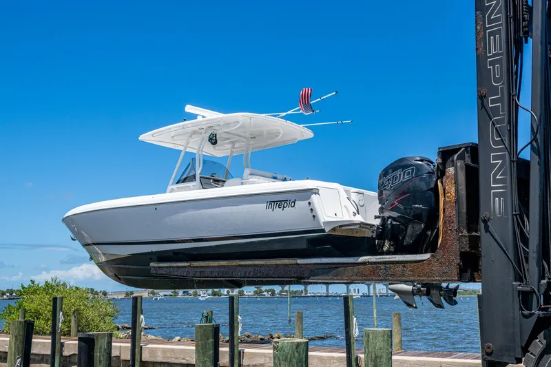  Yacht Photos Pics 2010 Intrepid 323 OPEN boat lifted by crane near waterfront.