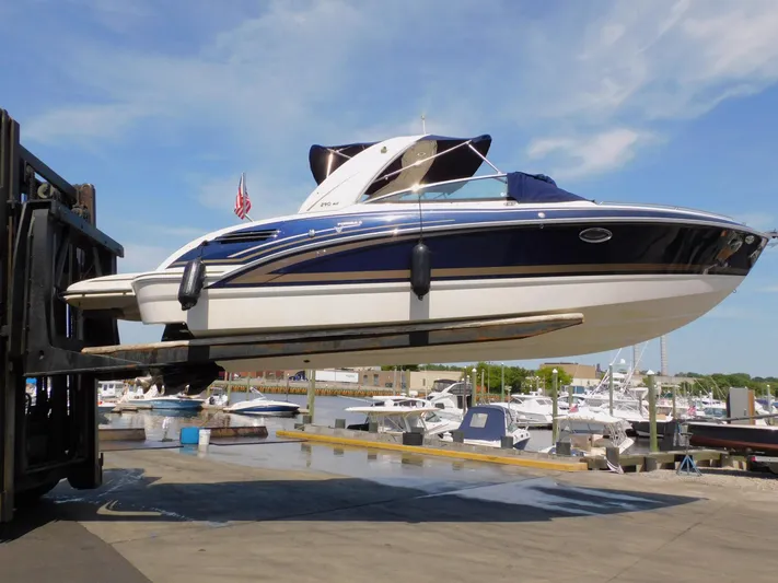 Tide Runner Yacht Photos Pics 2015 Formula Bowrider 290 being lifted at a marina, clear sky background.