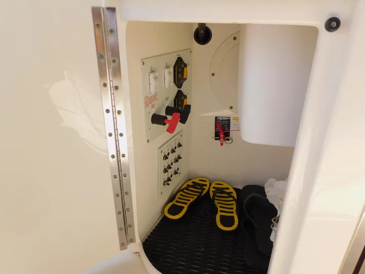 Tide Runner Yacht Photos Pics 2015 Formula Bowrider 290 interior compartment with control panel and shoes.