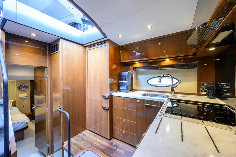 Alpha Dog Yacht Photos Pics Luxurious interior of a 2015 Princess S62 yacht with modern kitchen and wood finishes.