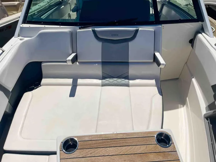  Yacht Photos Pics 2021 Chaparral 300 OSX boat interior with cushioned seating and wooden table.