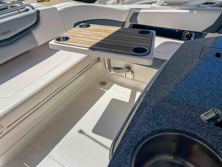  Yacht Photos Pics 2021 Chaparral 300 OSX boat interior with seating and wooden table.