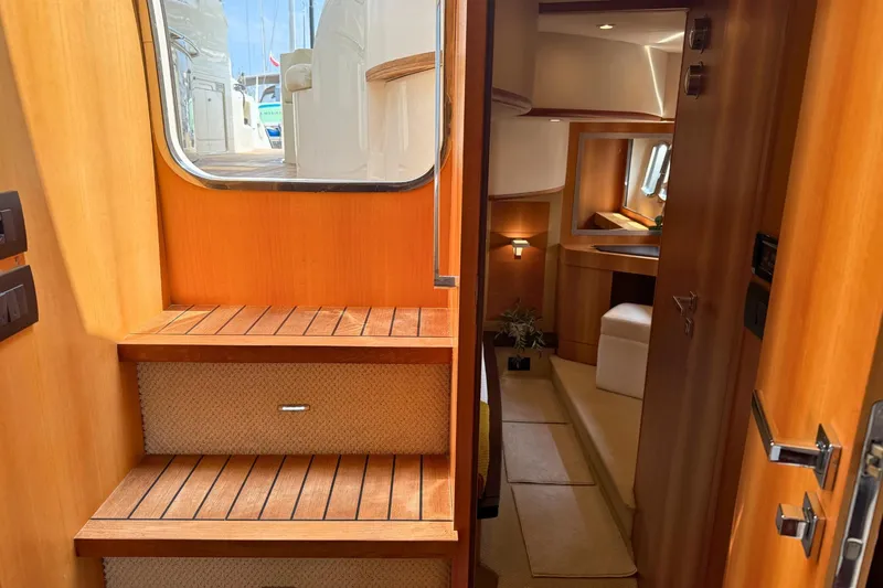  Yacht Photos Pics Interior view of 2007 Absolute 56 HT yacht, featuring wooden stairs and cozy cabin area.