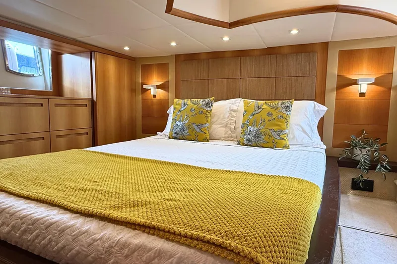  Yacht Photos Pics Luxurious bedroom interior of 2007 Absolute 56 HT yacht with yellow accents and wood paneling.