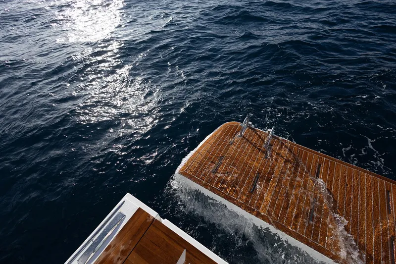  Yacht Photos Pics Aventura 38 Motor Yacht 2026, wooden deck, ocean view, sunlight reflecting on water.