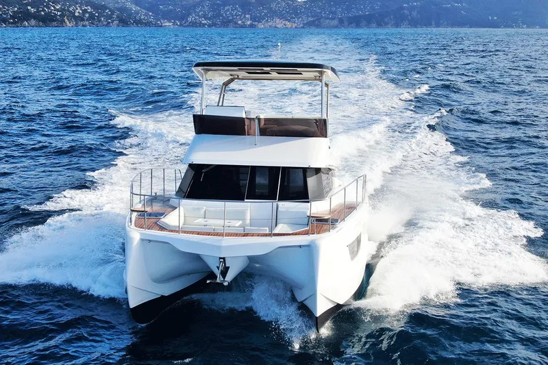  Yacht Photos Pics 2026 Aventura 38 Motor Yacht cruising on open sea with scenic mountain backdrop.