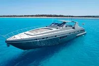 2004 Mangusta 80 Open yacht on clear blue water, near a sandy coastline.
